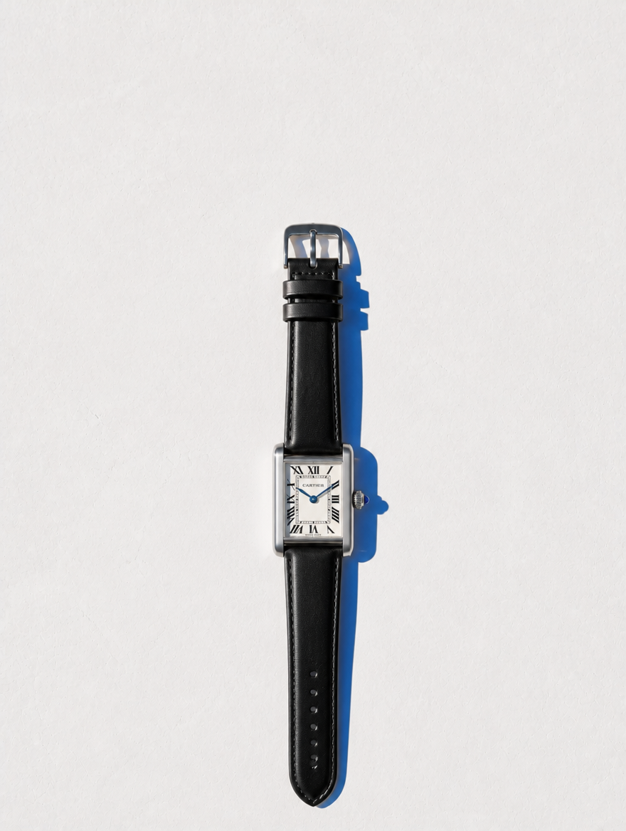 Cartier Tank Must completo en flat lay sobre pared Santorini