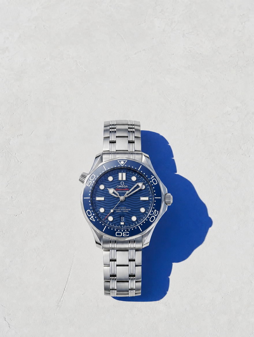 Omega Seamaster completo en flat lay sobre pared Santorini