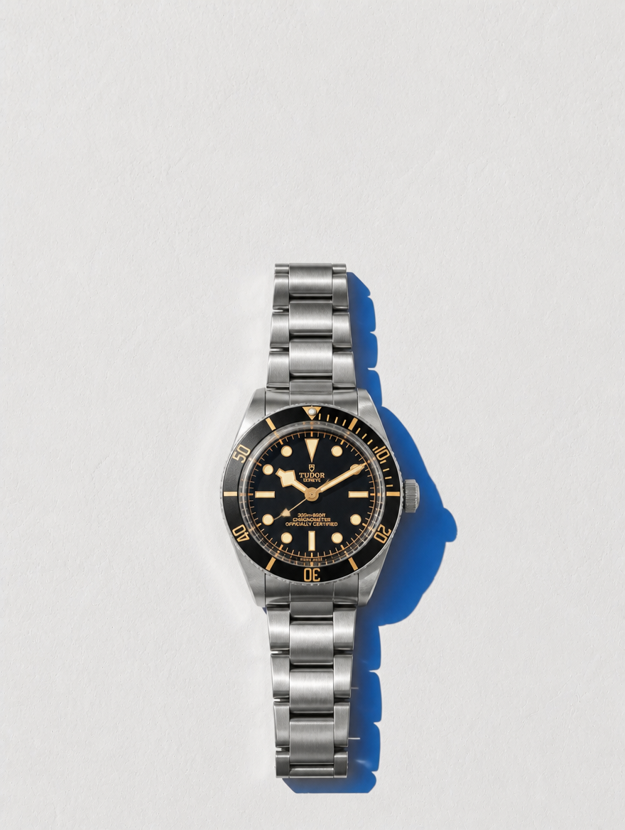 Tudor Black Bay Fifty-Eight completo en flat lay sobre pared Santorini